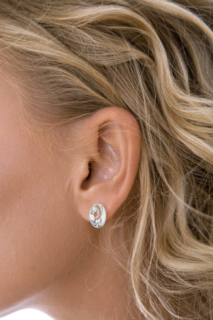 Close up of an ear wearing a silver wirl stud earring